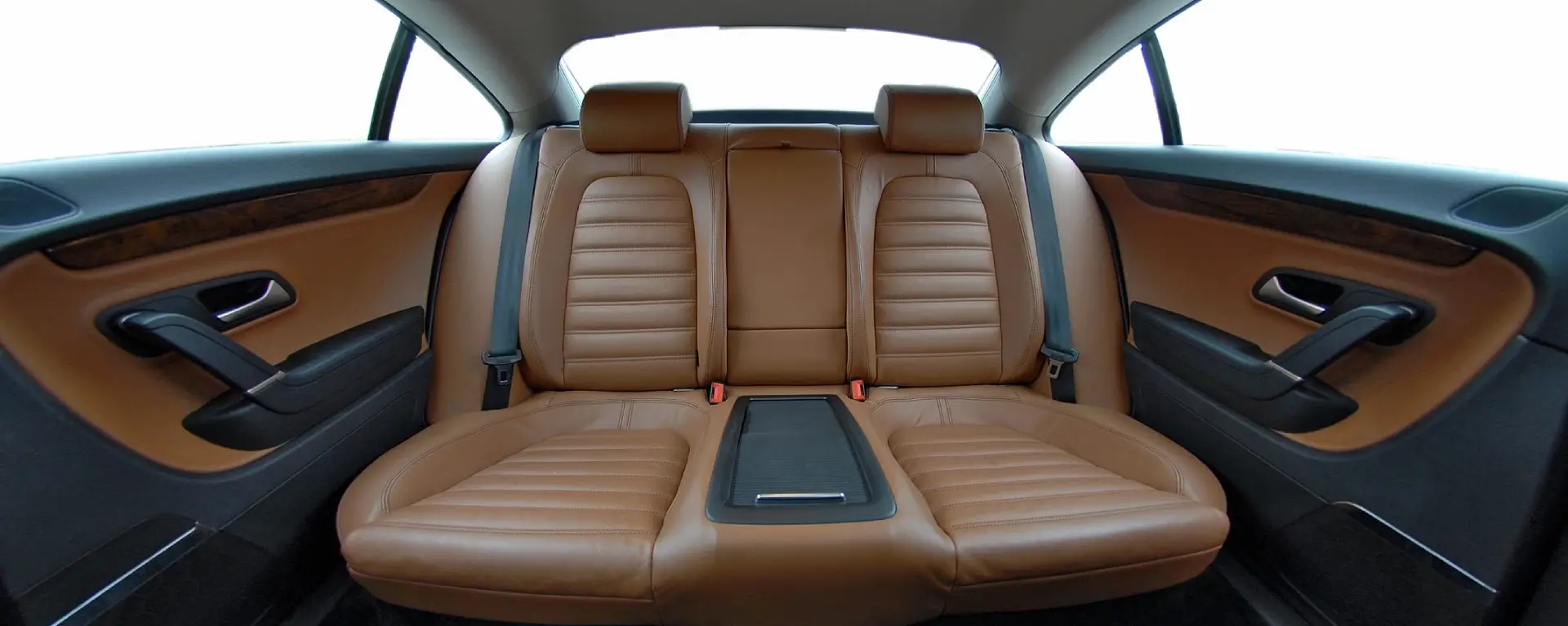 Luxurious brown leather car backseat with center armrest.
