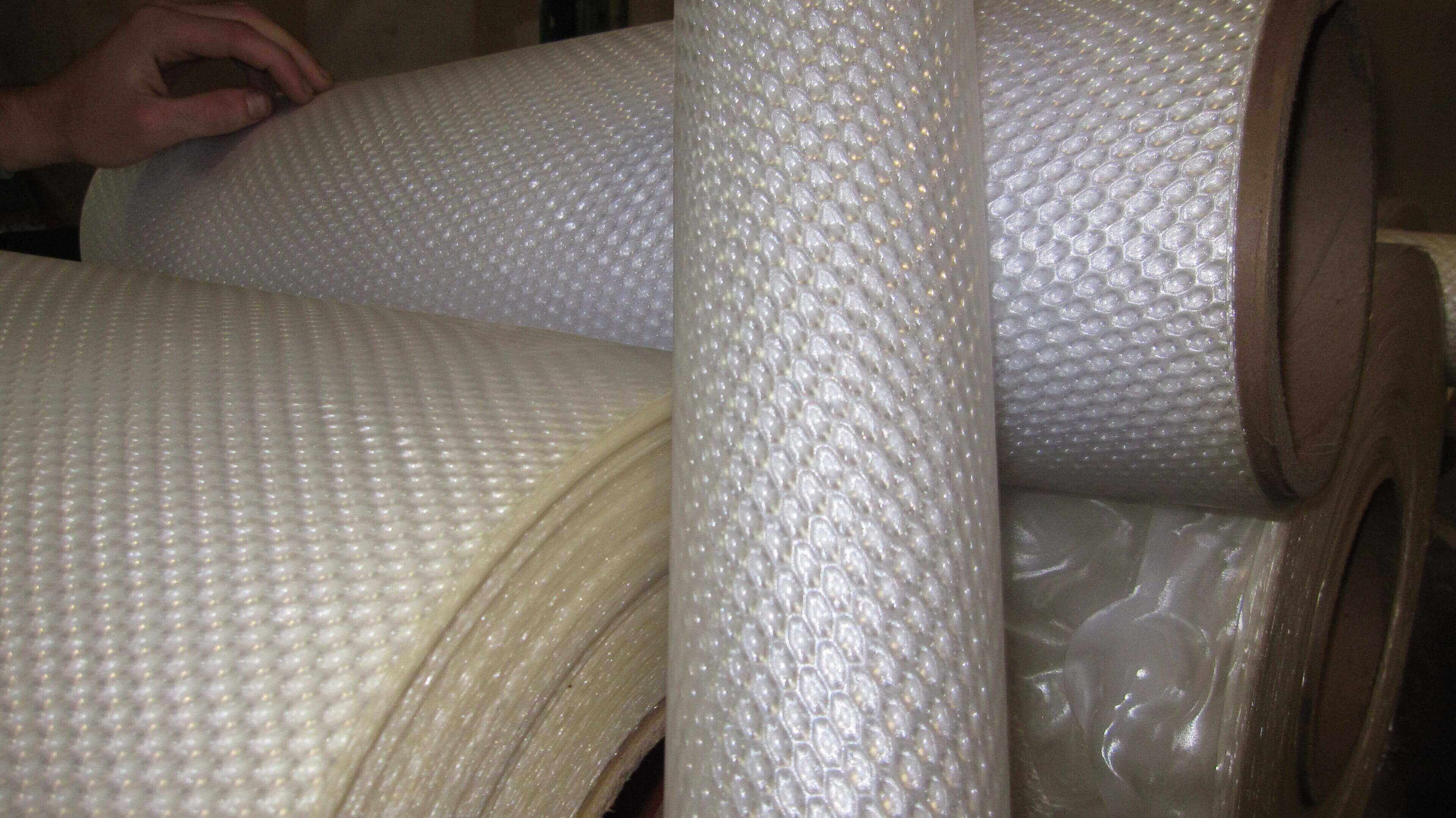 Rolls of textured fiberglass fabric.